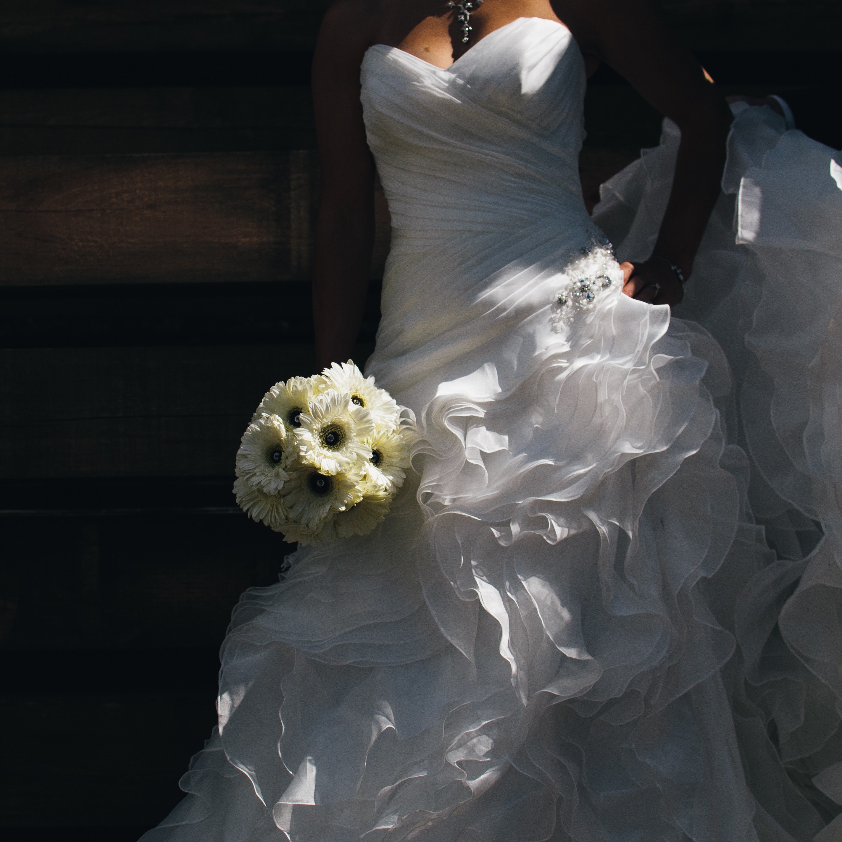 White strapless sweetheart neckline wedding dress asymmetrical pleated bodice and ruffle skirt